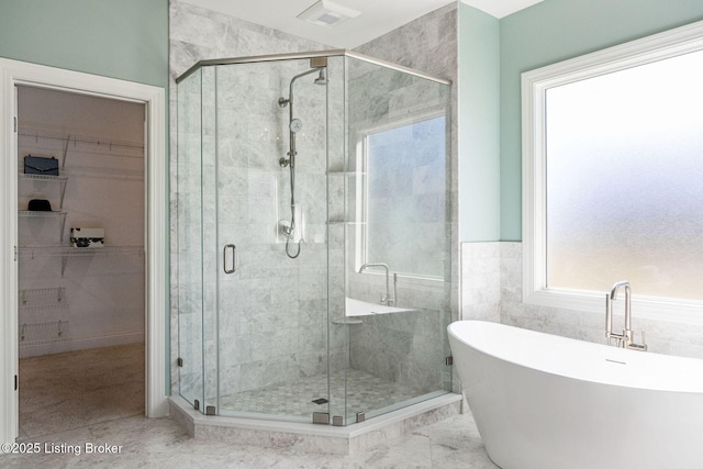 bathroom with visible vents, a freestanding tub, a stall shower, and a spacious closet