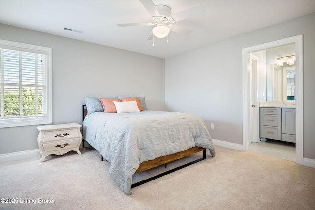 bedroom with connected bathroom, ceiling fan, light carpet, baseboards, and visible vents