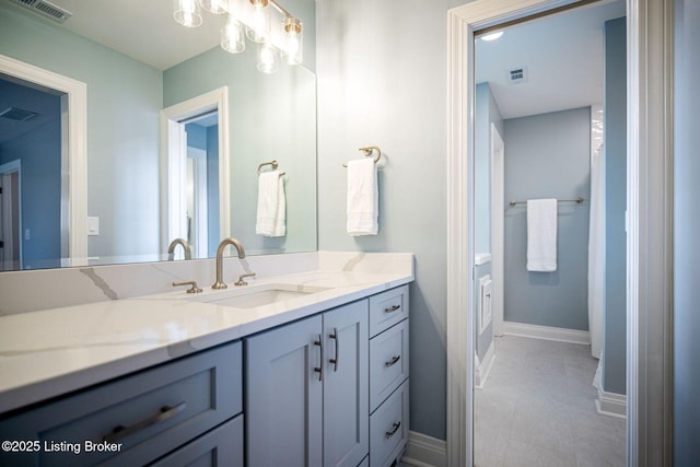 bathroom with baseboards, visible vents, and vanity