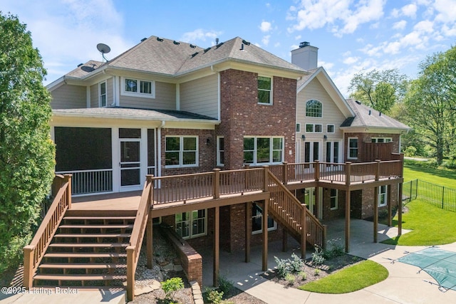 rear view of property with brick siding, a wooden deck, stairs, and a patio area