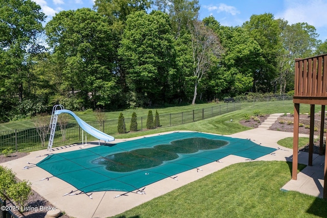 view of swimming pool featuring a fenced in pool, fence, a water slide, and a yard