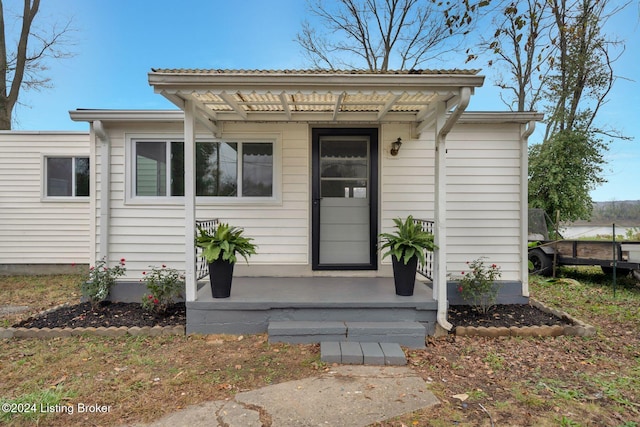 view of exterior entry with a pergola
