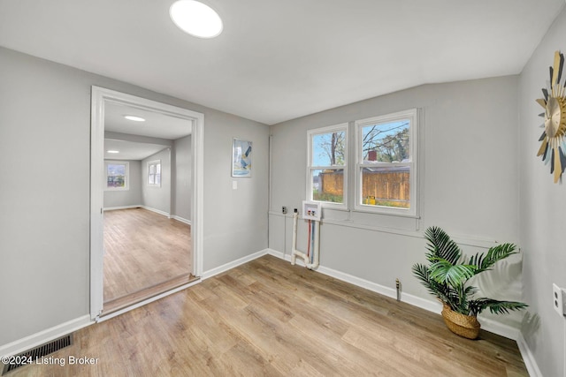 interior space featuring baseboards, light wood finished floors, visible vents, and plenty of natural light