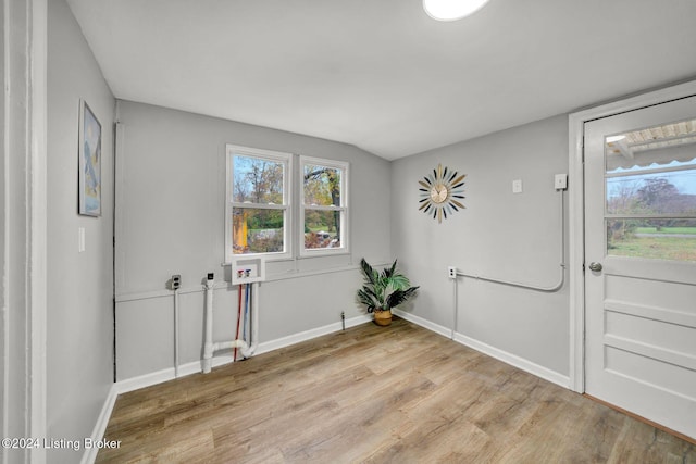 doorway to outside featuring light wood-style flooring, a healthy amount of sunlight, and baseboards