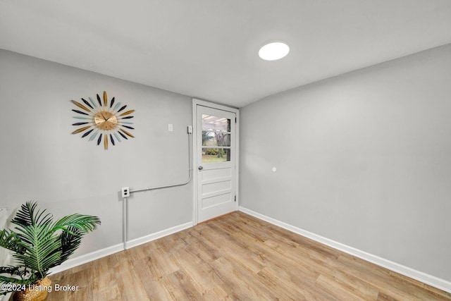 unfurnished room featuring baseboards and light wood-style floors