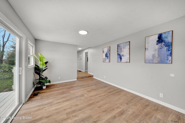 empty room featuring baseboards, wood finished floors, and visible vents
