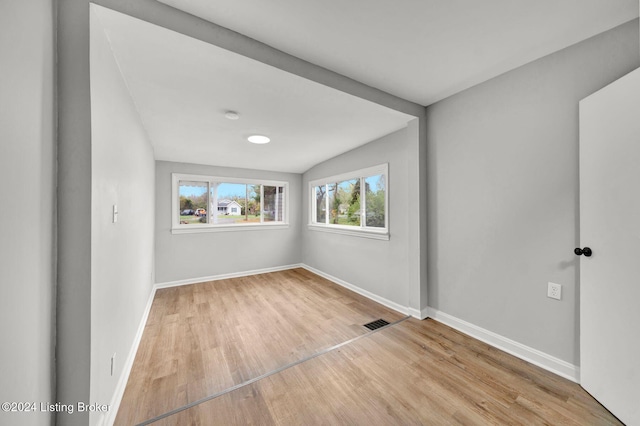 unfurnished room featuring baseboards, wood finished floors, and visible vents