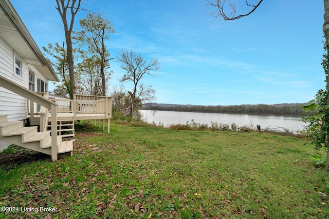 view of yard featuring a deck with water view and stairs