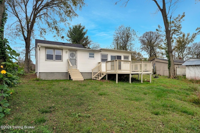 back of house featuring an outbuilding, entry steps, a deck, a yard, and a shed