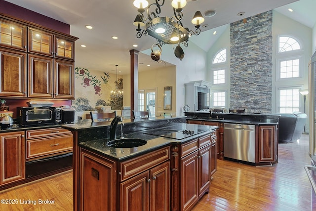 320 Longview Park Pl, Louisville, KY 40245 - kitchen with stainless steel dishwasher, black electric stovetop, open floor plan, light wood finished floors, and high vaulted ceiling
