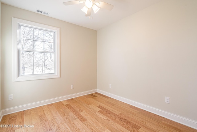 spare room featuring ceiling fan, light wood finished floors, baseboards, and visible vents