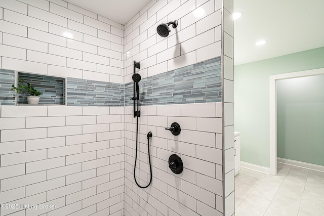 bathroom with baseboards, tiled shower, and recessed lighting