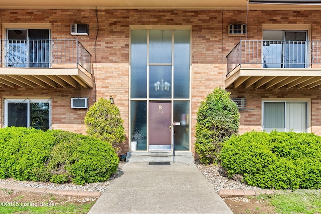 entrance to property featuring brick siding and central AC unit