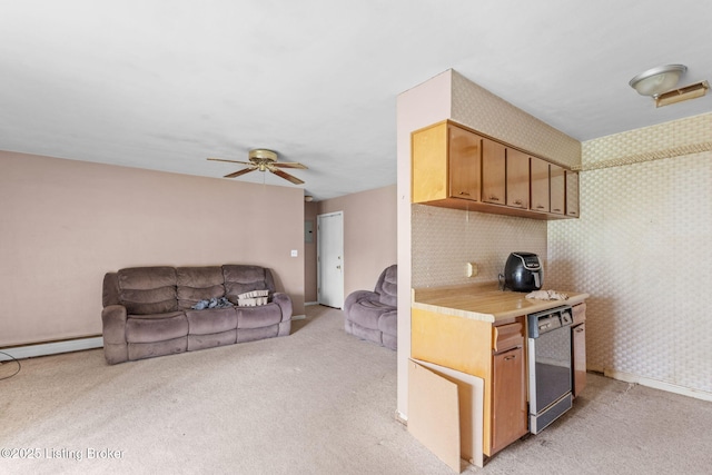 kitchen featuring light countertops, a ceiling fan, a baseboard radiator, dishwashing machine, and light carpet