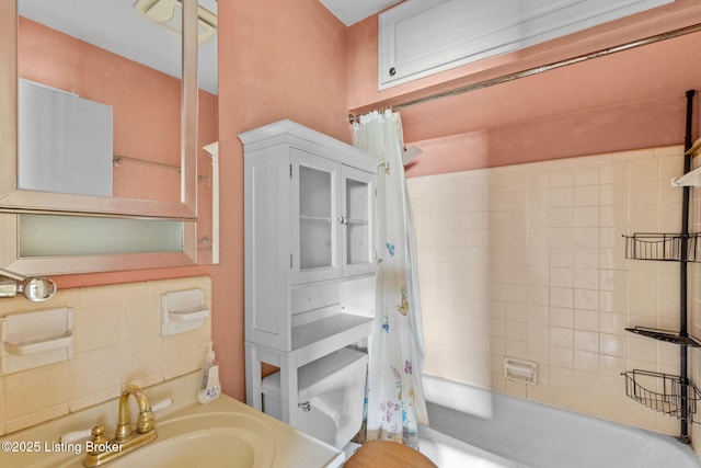 bathroom featuring shower / bath combo with shower curtain, a sink, and toilet