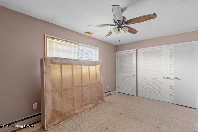 unfurnished bedroom with visible vents, a baseboard radiator, ceiling fan, baseboard heating, and carpet flooring