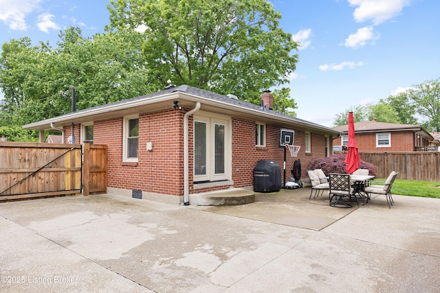 6507 S Dr, Louisville, KY 40272 - rear view of house with brick siding, a patio, a chimney, and a gate