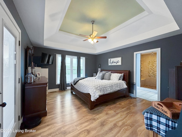 444 Wire Ln, Bardstown, KY 40004 - bedroom featuring connected bathroom, ceiling fan, a tray ceiling, and light wood-type flooring