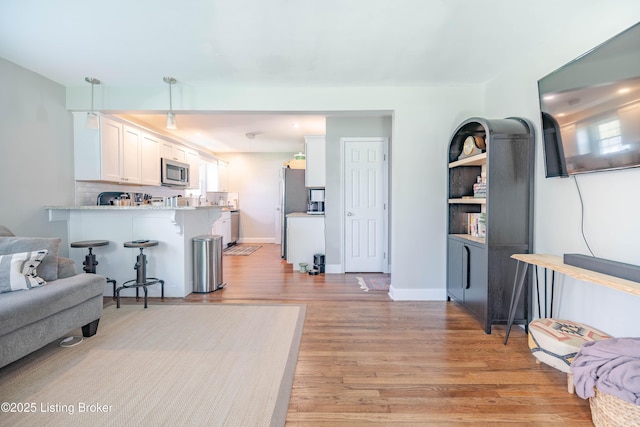 living room with baseboards and light wood-style floors
