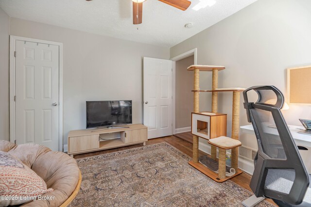 office with ceiling fan, wood finished floors, and baseboards