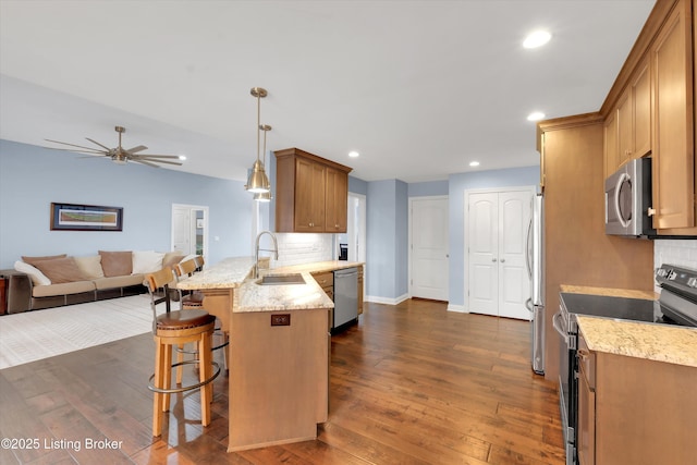 178 Bluffs Edge Dr, Mt Washington, KY 40047 - kitchen featuring a peninsula, backsplash, dark wood-type flooring, stainless steel appliances, and a sink
