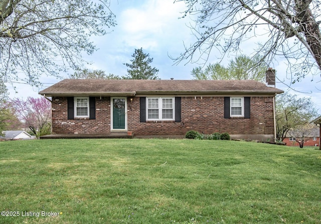 ranch-style house with roof with shingles, a front yard, brick siding, and a chimney