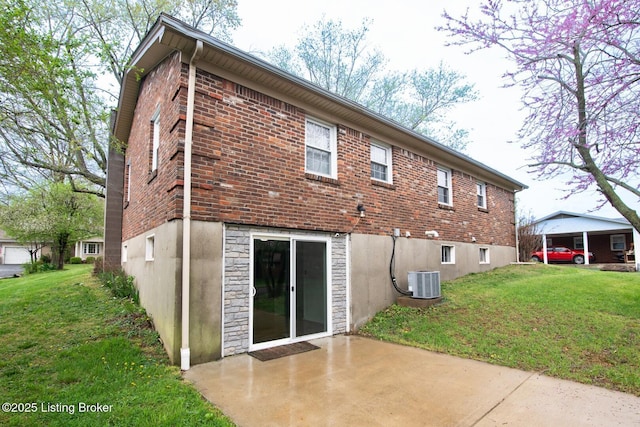 back of house featuring central AC unit, stone siding, a patio, and a lawn