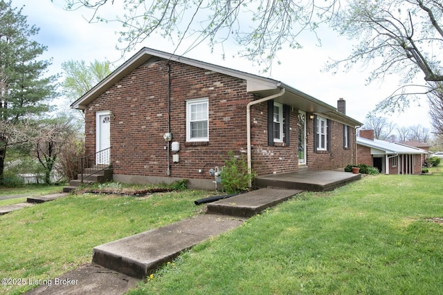 view of home's exterior featuring a chimney, a lawn, and brick siding