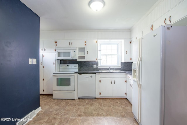 kitchen featuring white appliances, backsplash, dark countertops, white cabinets, and a sink