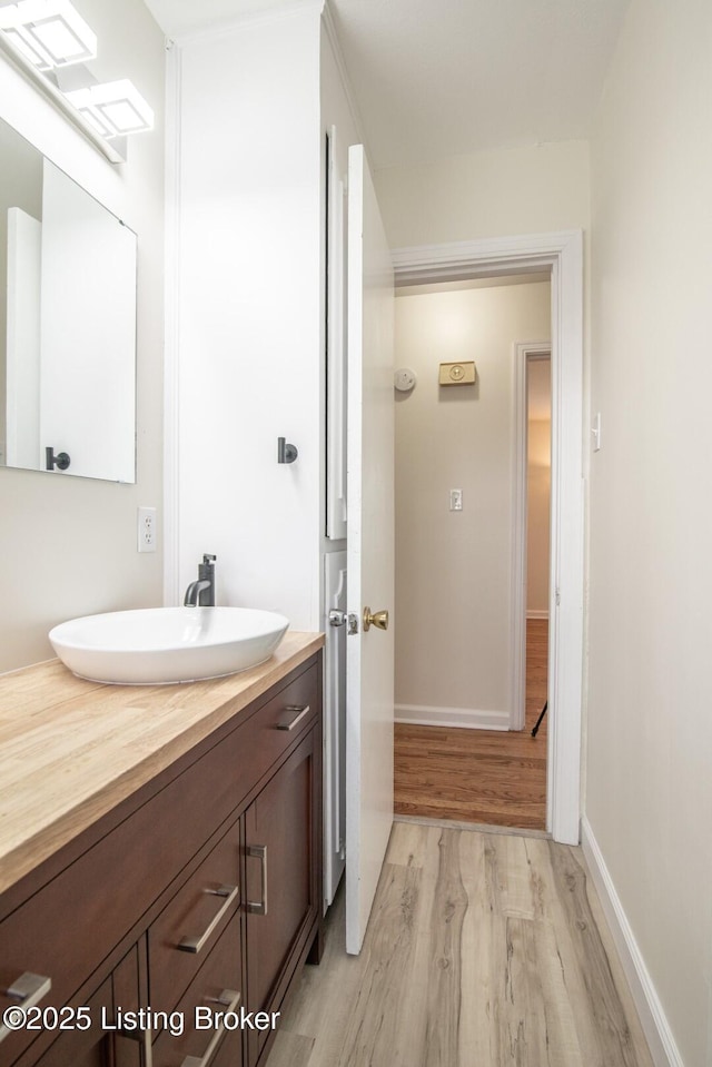 bathroom with vanity, baseboards, and wood finished floors