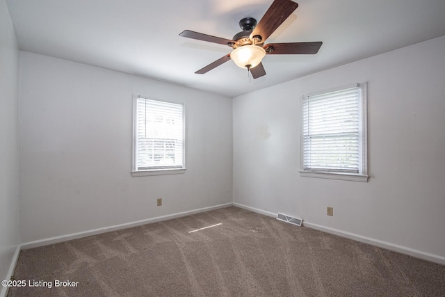 spare room with baseboards, carpet flooring, ceiling fan, and visible vents