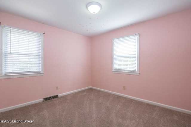 carpeted empty room featuring visible vents and baseboards