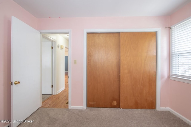 unfurnished bedroom featuring a closet, baseboards, and carpet floors