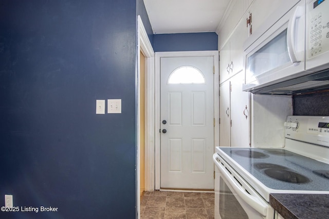 kitchen featuring dark countertops and white appliances