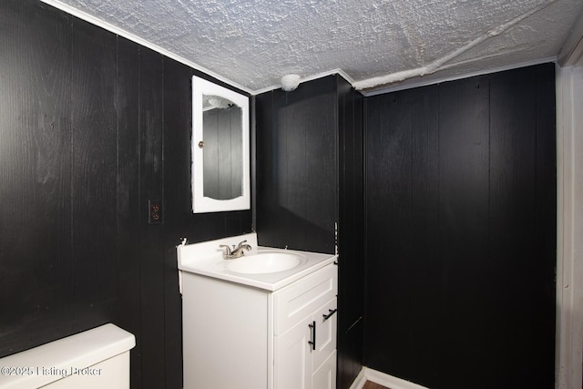 half bathroom with wood walls, vanity, and toilet