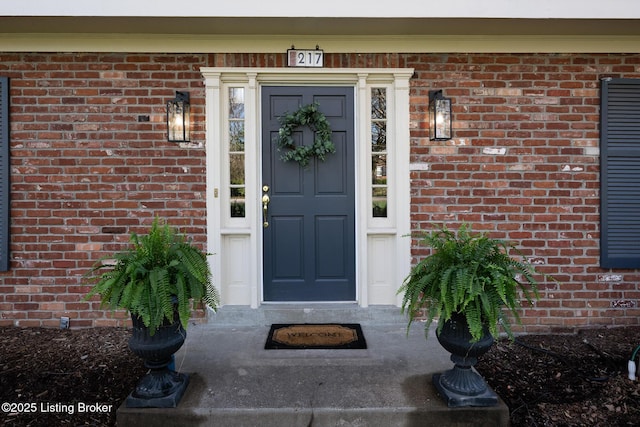 view of exterior entry with brick siding