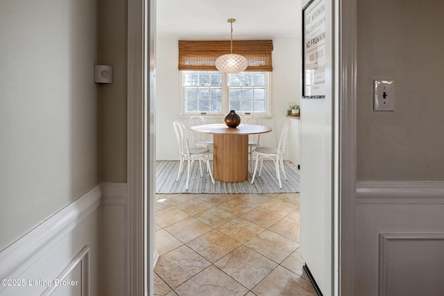 dining room featuring light tile patterned flooring and wainscoting