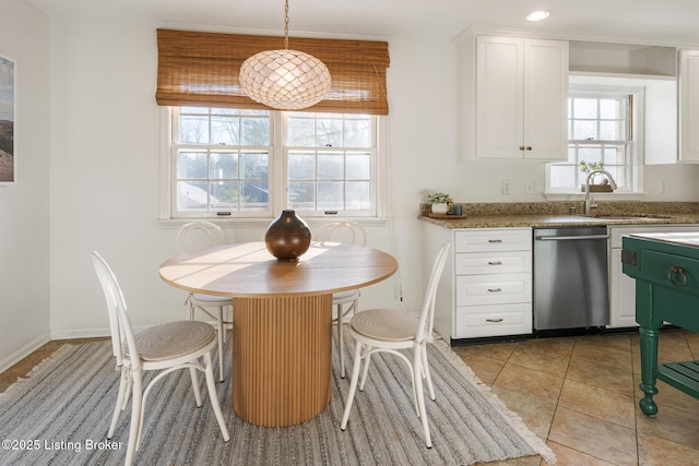 kitchen with dishwasher, white cabinetry, and a sink