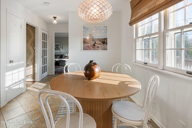 dining area with baseboards and light tile patterned flooring