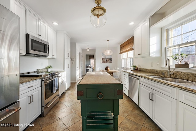 kitchen featuring a center island, a sink, white cabinets, and stainless steel appliances