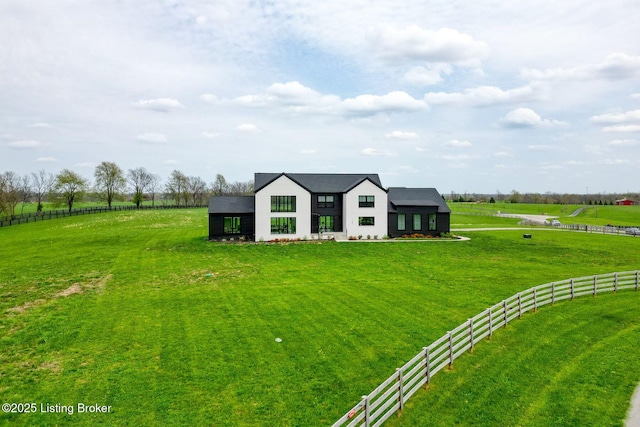 view of front of home featuring a rural view, a front yard, and fence