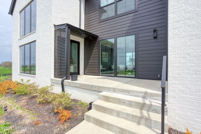entrance to property featuring brick siding