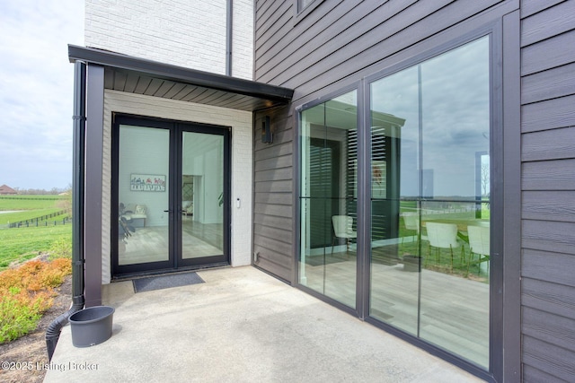 property entrance featuring brick siding and french doors