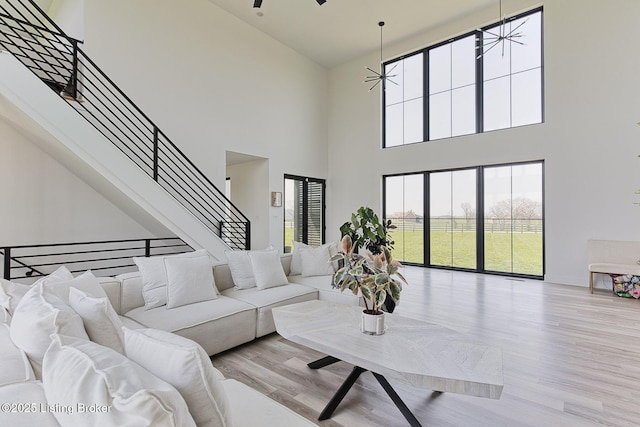 living area featuring stairway, a high ceiling, and wood finished floors