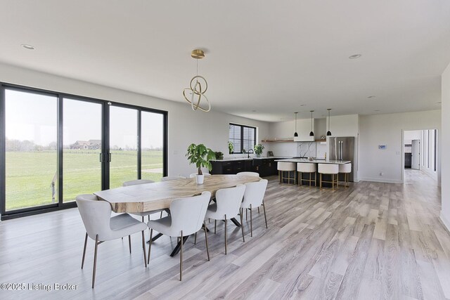 dining space with baseboards and light wood-style floors