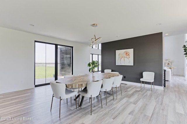 dining area featuring recessed lighting, light wood-type flooring, baseboards, and an inviting chandelier