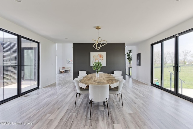 dining space featuring plenty of natural light, baseboards, and light wood-style floors