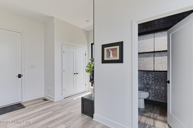 corridor with light wood finished floors and baseboards