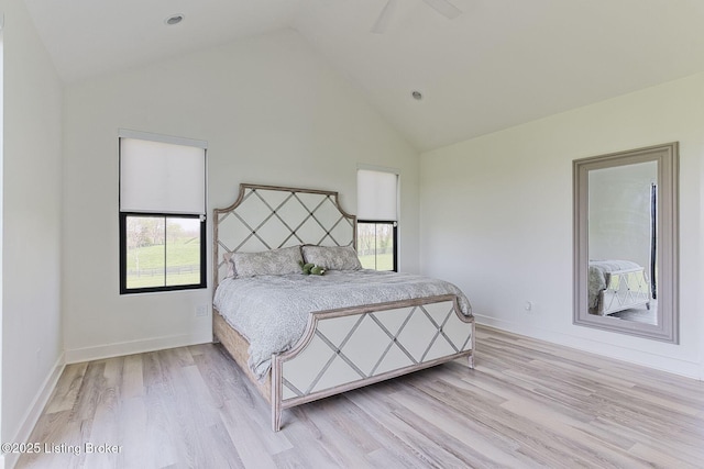 bedroom with high vaulted ceiling, ceiling fan, baseboards, and light wood-style floors