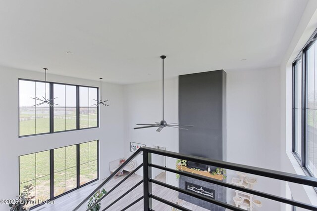 hall with a wealth of natural light and an upstairs landing